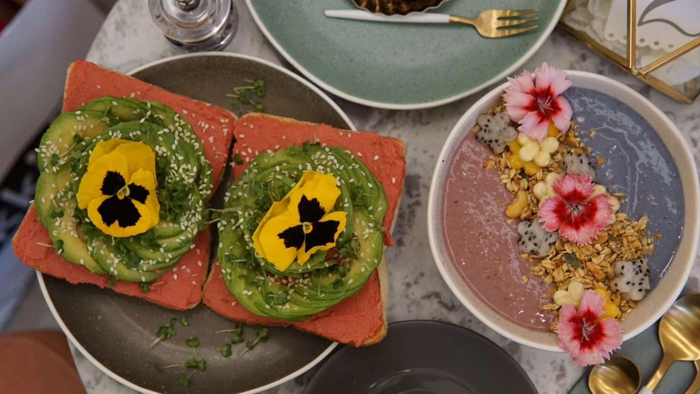 Flatlay of Rose Avocado Toast &amp; Pastel Rainbow Smoothie