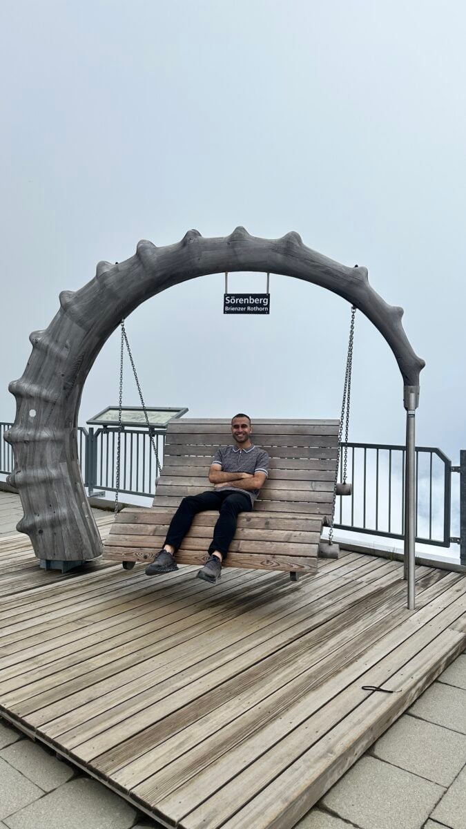 Adil Musa sitting on the arched photo bench at Brienz Rothorn